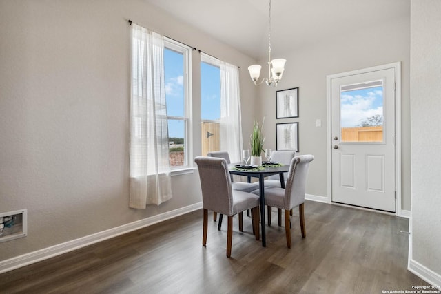 dining area with a healthy amount of sunlight, dark hardwood / wood-style floors, and a notable chandelier