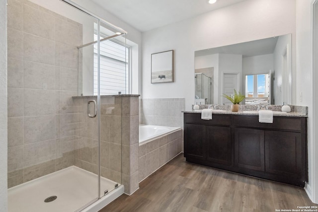 bathroom with hardwood / wood-style flooring, plenty of natural light, and independent shower and bath