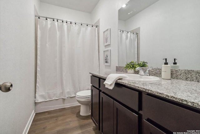 full bathroom featuring hardwood / wood-style flooring, vanity, toilet, and shower / tub combo