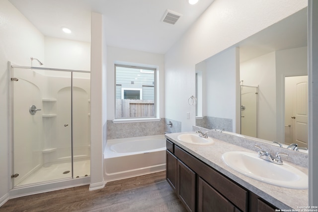 bathroom featuring hardwood / wood-style flooring, vanity, and plus walk in shower