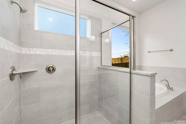 bathroom featuring a healthy amount of sunlight and plus walk in shower