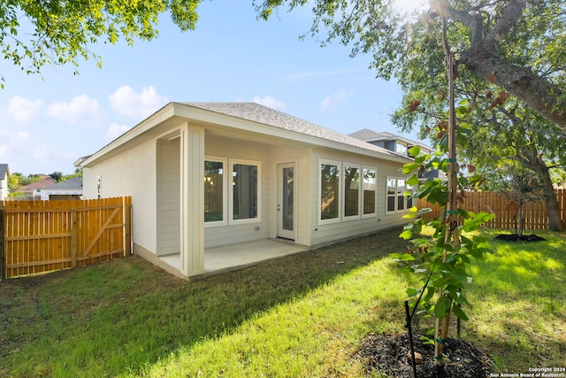 back of property with a patio area and a yard