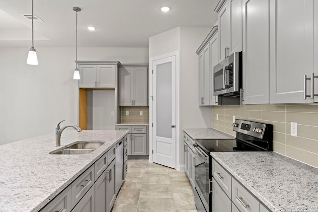 kitchen with appliances with stainless steel finishes, hanging light fixtures, backsplash, and sink