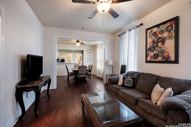 living room featuring dark wood-type flooring and ceiling fan