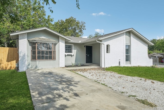 ranch-style home featuring a front yard and a carport