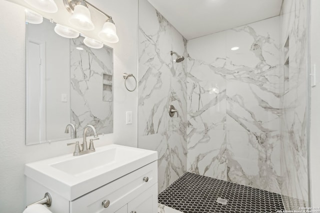 bathroom with tiled shower and vanity