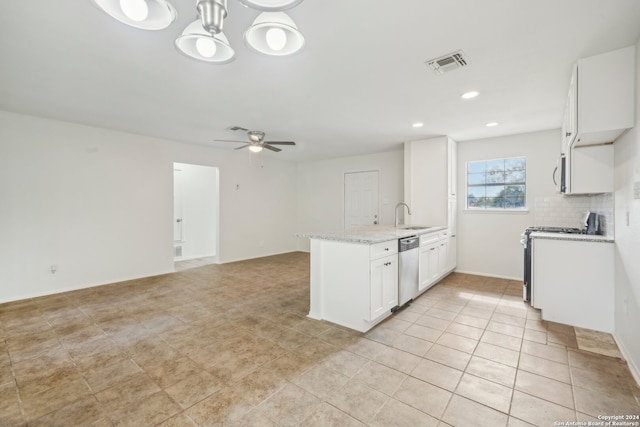 kitchen featuring stainless steel appliances, light stone counters, white cabinets, sink, and decorative light fixtures