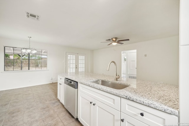 kitchen with light stone counters, white cabinetry, hanging light fixtures, sink, and stainless steel dishwasher