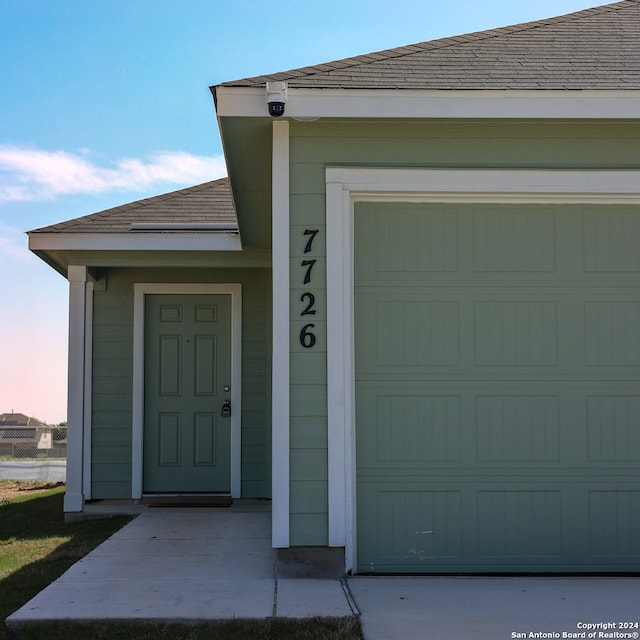 exterior entry at dusk featuring a garage