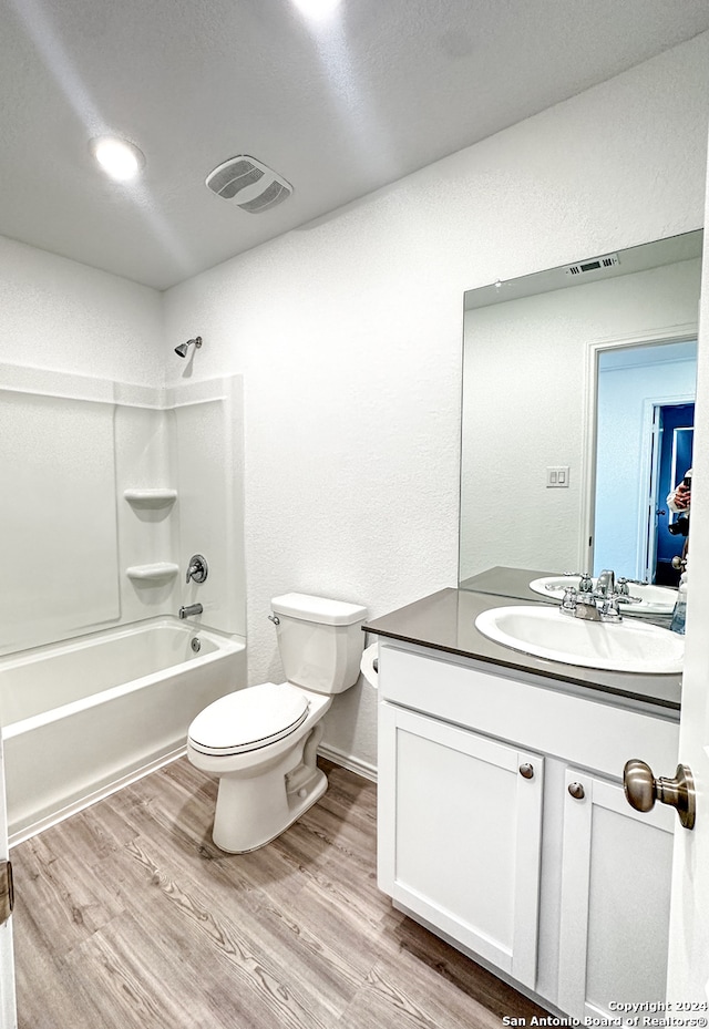 full bathroom featuring hardwood / wood-style floors, vanity, toilet, and tub / shower combination