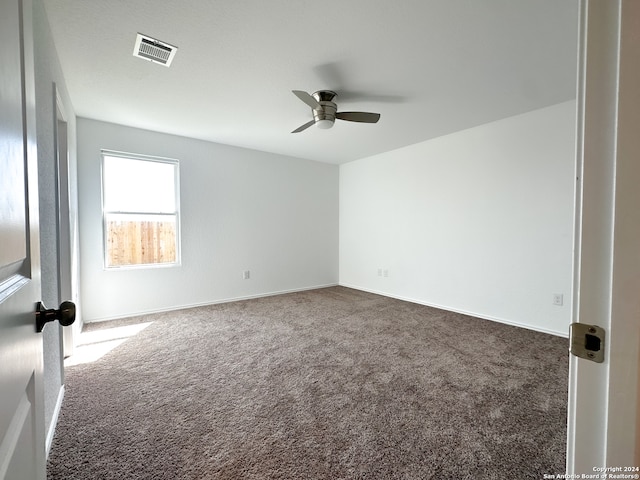 carpeted spare room featuring ceiling fan