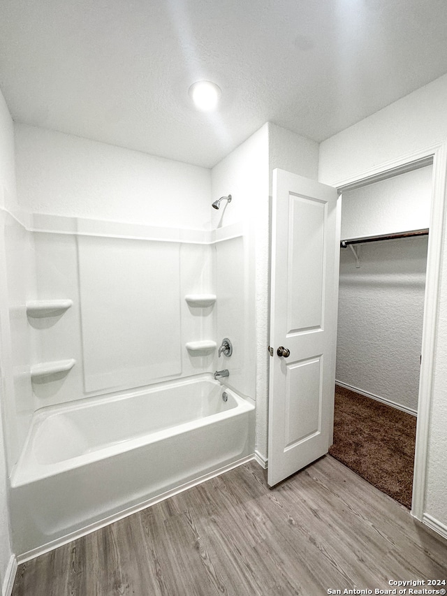 bathroom with hardwood / wood-style flooring and shower / bathing tub combination