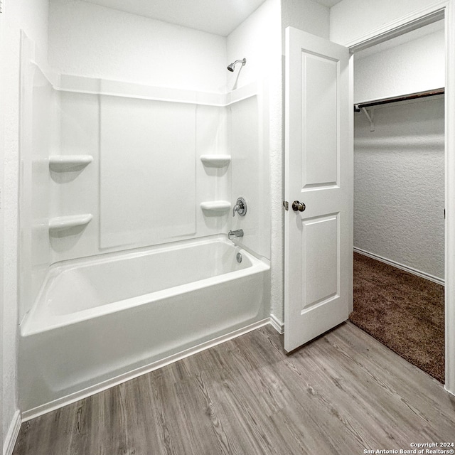 bathroom with wood-type flooring and  shower combination