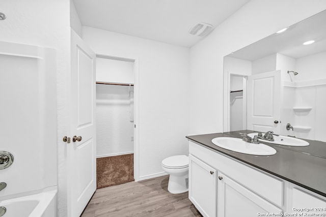 full bathroom featuring vanity, wood-type flooring, tub / shower combination, and toilet