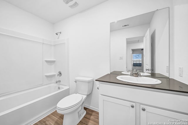 full bathroom with vanity, hardwood / wood-style floors,  shower combination, and toilet