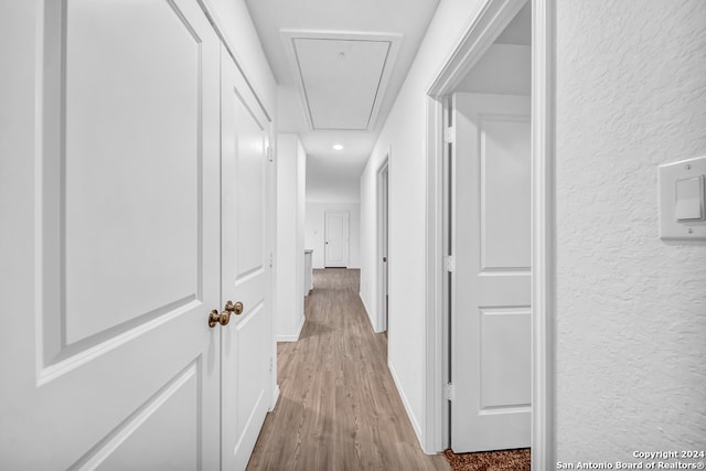 hallway with light hardwood / wood-style floors