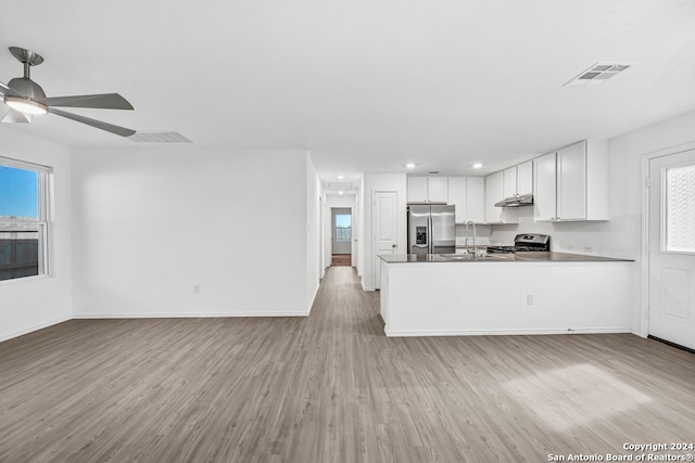 kitchen featuring a healthy amount of sunlight, white cabinetry, stainless steel appliances, and light hardwood / wood-style floors