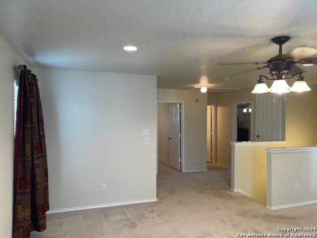 kitchen featuring ceiling fan, a textured ceiling, and light colored carpet