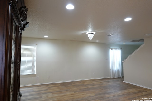 spare room featuring a textured ceiling and hardwood / wood-style flooring