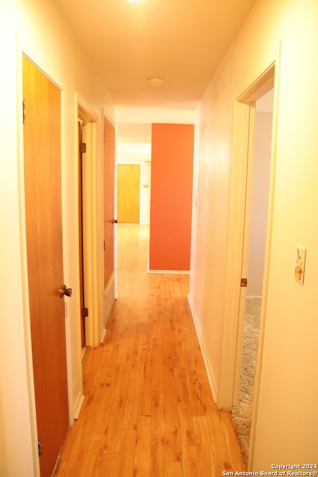 hallway with light hardwood / wood-style floors