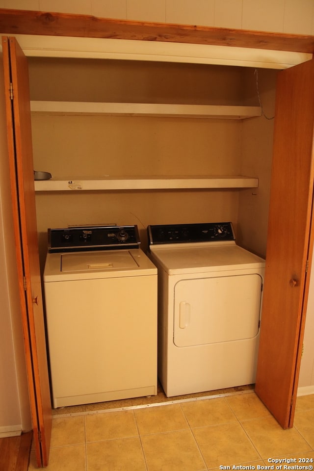 washroom with light tile flooring and washer and clothes dryer