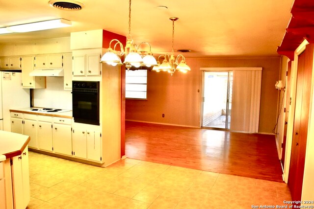 kitchen featuring oven, white cooktop, hanging light fixtures, light tile flooring, and an inviting chandelier