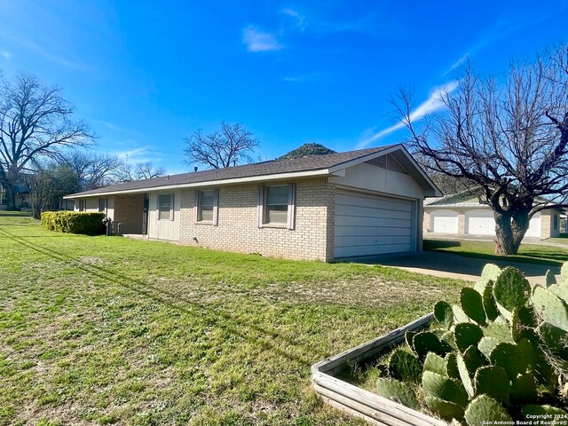 view of side of home featuring a lawn and a garage