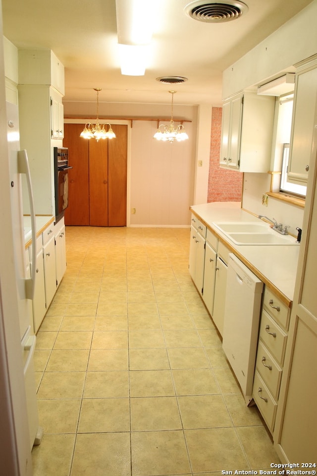 kitchen featuring hanging light fixtures, white appliances, a notable chandelier, and white cabinetry