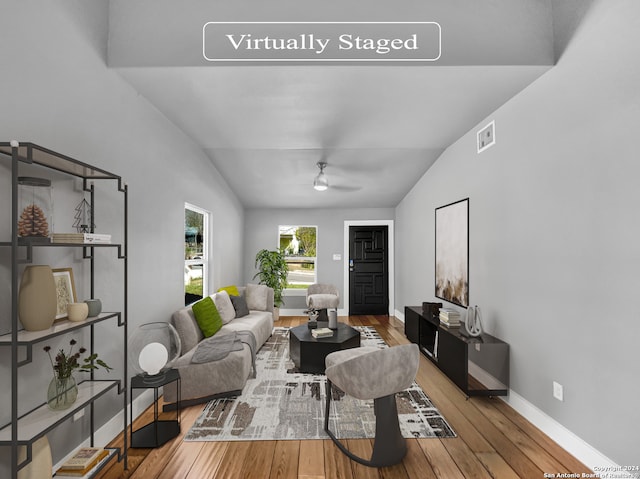 living room featuring hardwood / wood-style floors, lofted ceiling, and ceiling fan