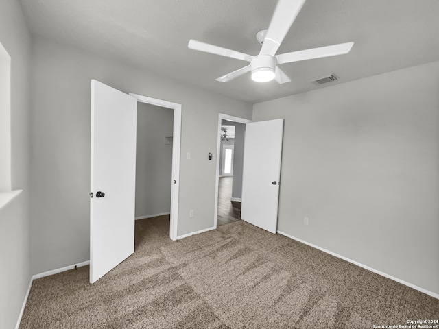 unfurnished bedroom featuring a closet, ceiling fan, and dark carpet