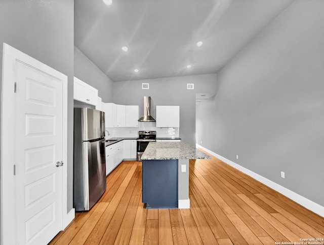 kitchen with white cabinets, a kitchen island, light wood-type flooring, and stainless steel appliances