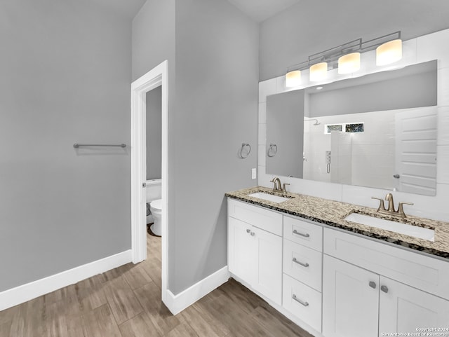 bathroom featuring hardwood / wood-style flooring, double vanity, and toilet