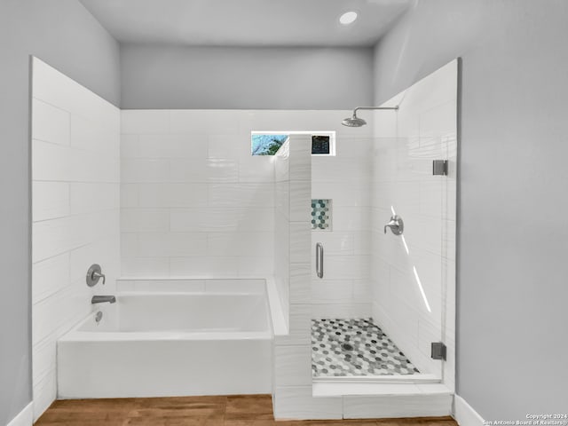 bathroom featuring shower with separate bathtub and wood-type flooring