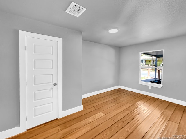 empty room featuring hardwood / wood-style flooring and a textured ceiling