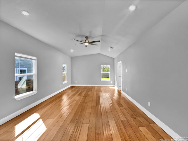 empty room featuring ceiling fan, light hardwood / wood-style floors, and vaulted ceiling