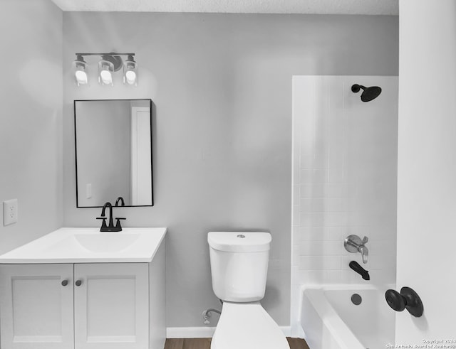 full bathroom with tiled shower / bath combo, vanity, hardwood / wood-style floors, a textured ceiling, and toilet