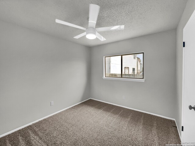 carpeted spare room featuring a textured ceiling and ceiling fan