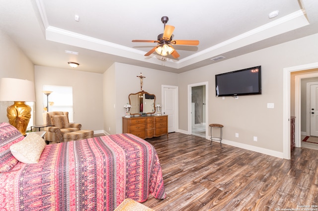 bedroom featuring ceiling fan, dark hardwood / wood-style floors, crown molding, and a tray ceiling