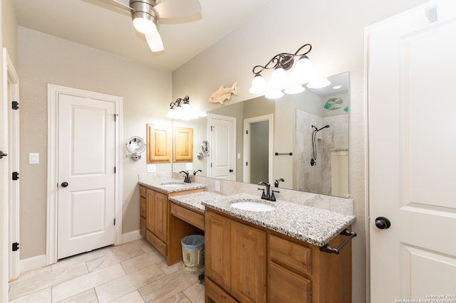 bathroom featuring tiled shower, ceiling fan, double vanity, and tile patterned flooring