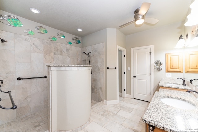 bathroom with dual bowl vanity, a tile shower, ceiling fan, and tile patterned flooring