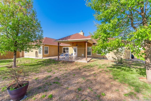 rear view of house featuring ceiling fan, a lawn, and a patio