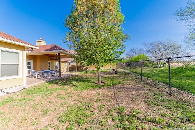 view of yard with ceiling fan and a patio area