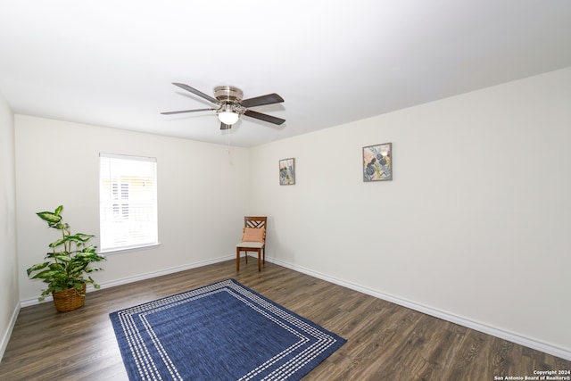 living area with dark hardwood / wood-style flooring and ceiling fan