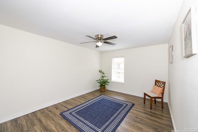 sitting room with dark wood-type flooring and ceiling fan