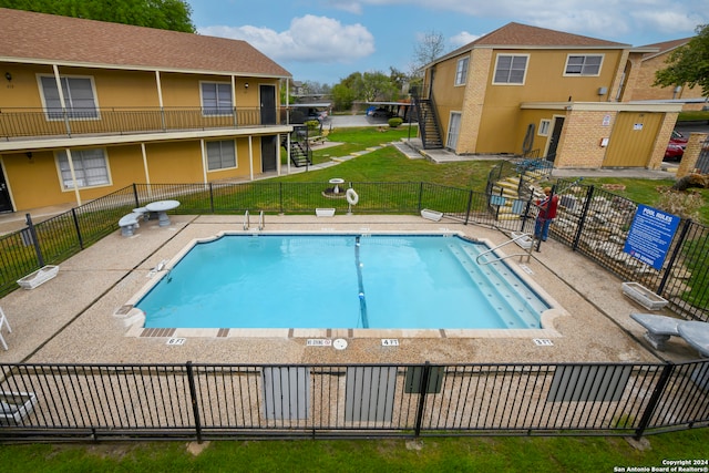 view of pool featuring a lawn and a patio area