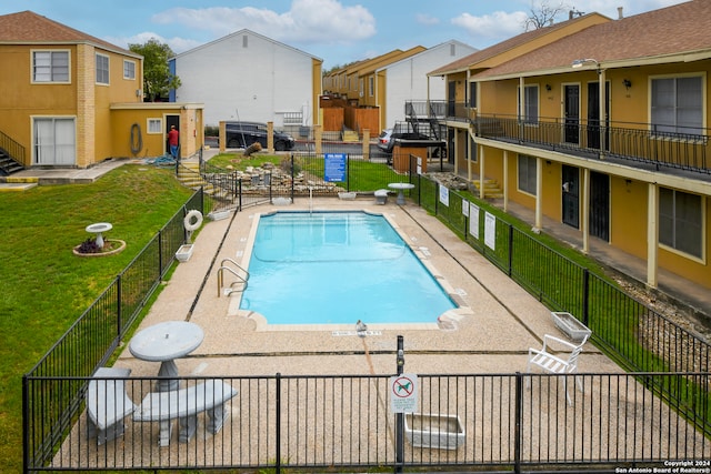 view of swimming pool with a yard and a patio