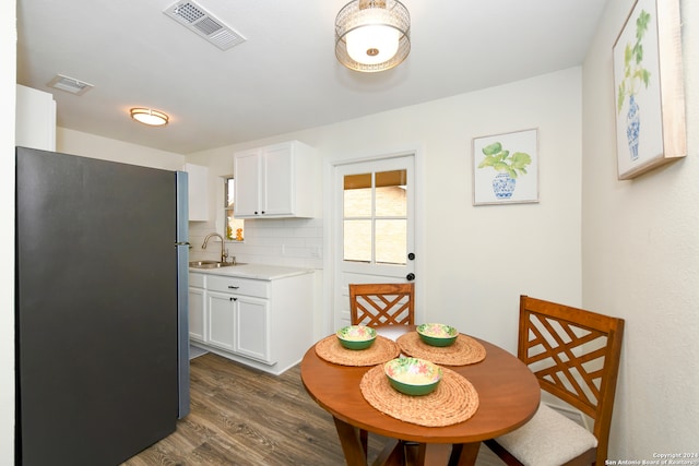 kitchen with dark hardwood / wood-style floors, sink, refrigerator, white cabinets, and tasteful backsplash