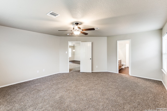 unfurnished bedroom featuring ceiling fan, ensuite bathroom, dark hardwood / wood-style flooring, and a textured ceiling