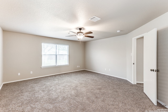 carpeted empty room featuring ceiling fan and a textured ceiling