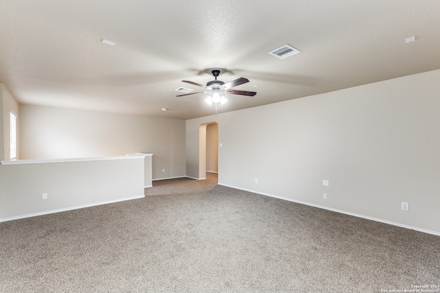 carpeted spare room with a textured ceiling and ceiling fan